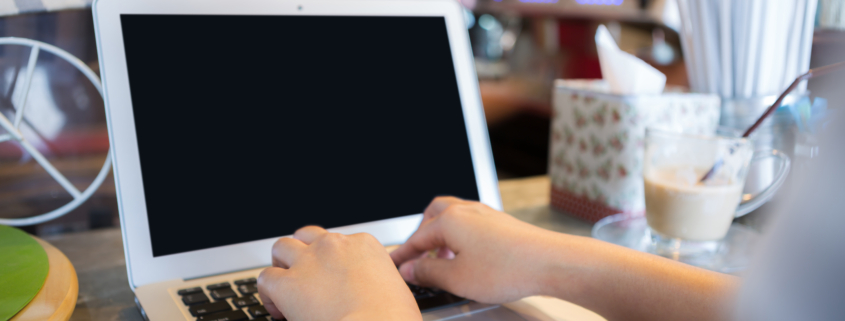 mujer usando un portatil en una cafeteria